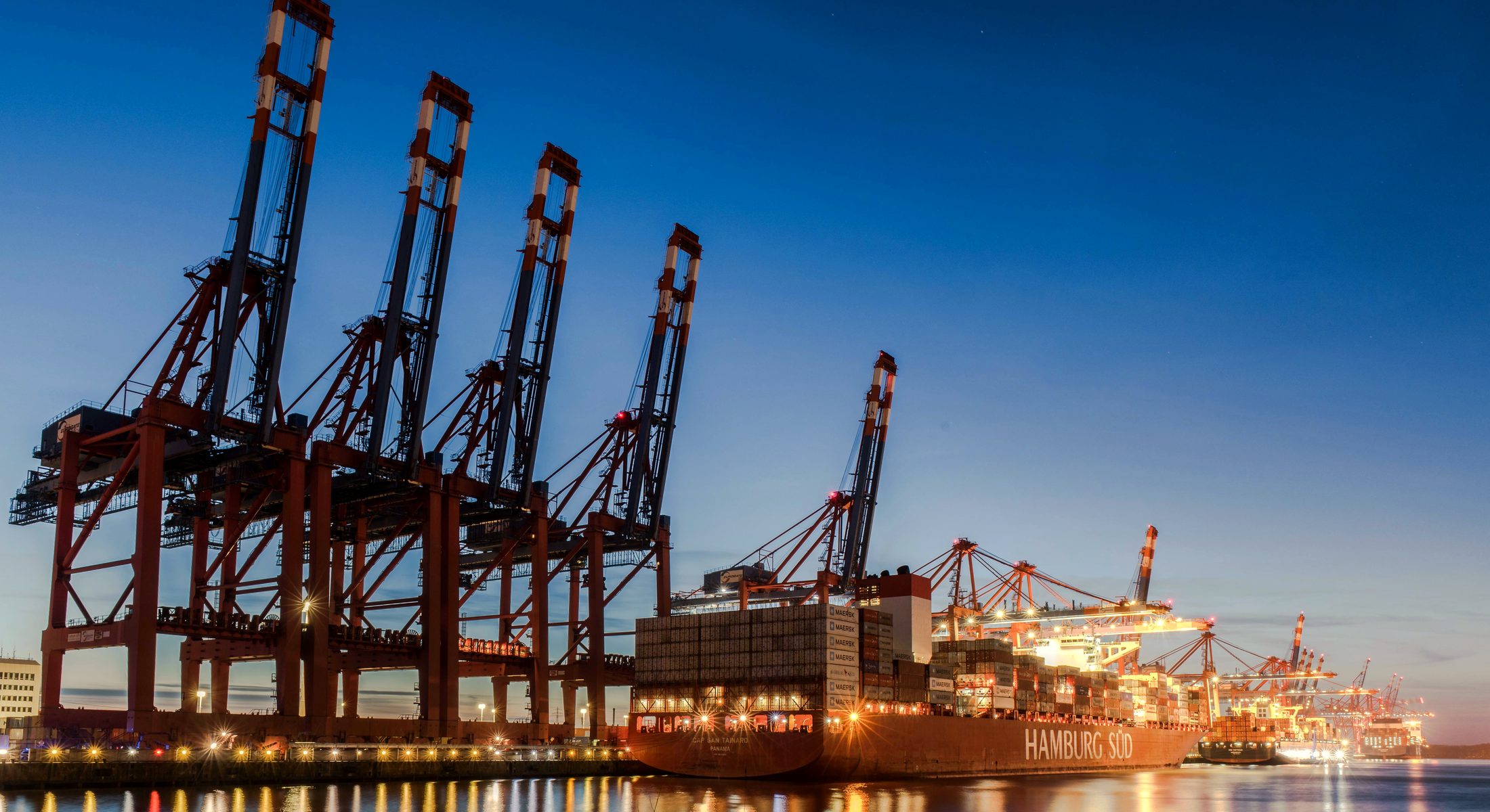 Container cranes standing over a terminal at dusk